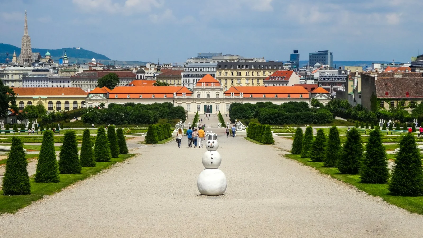 Grand palace gardens with a distant city skyline.