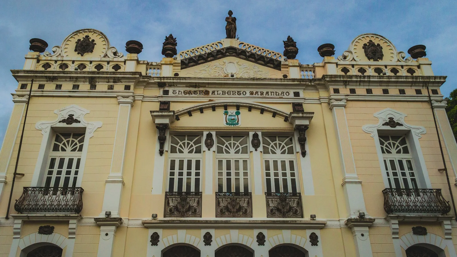 Ornate yellow building facade with decorative windows and balconies.