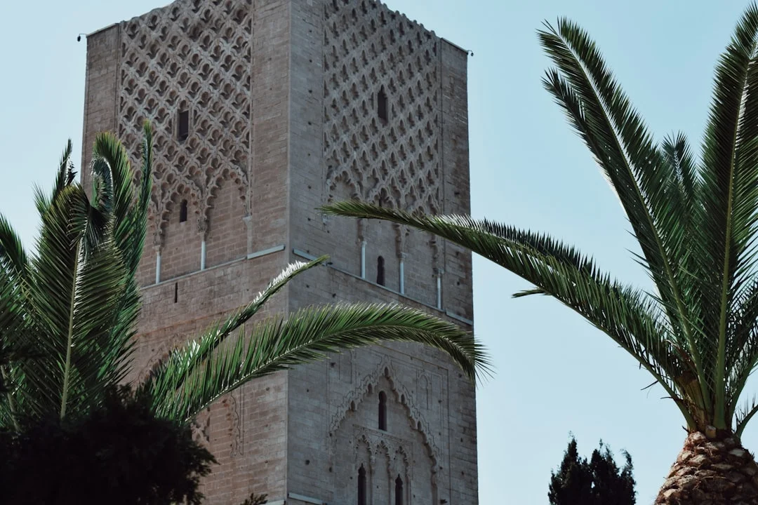 Hassan tower with palm trees against blue sky