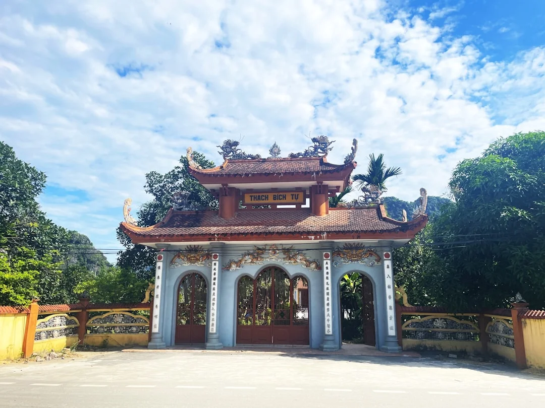 A gate with a small temple (Thach Bich) in the background, Vietnam