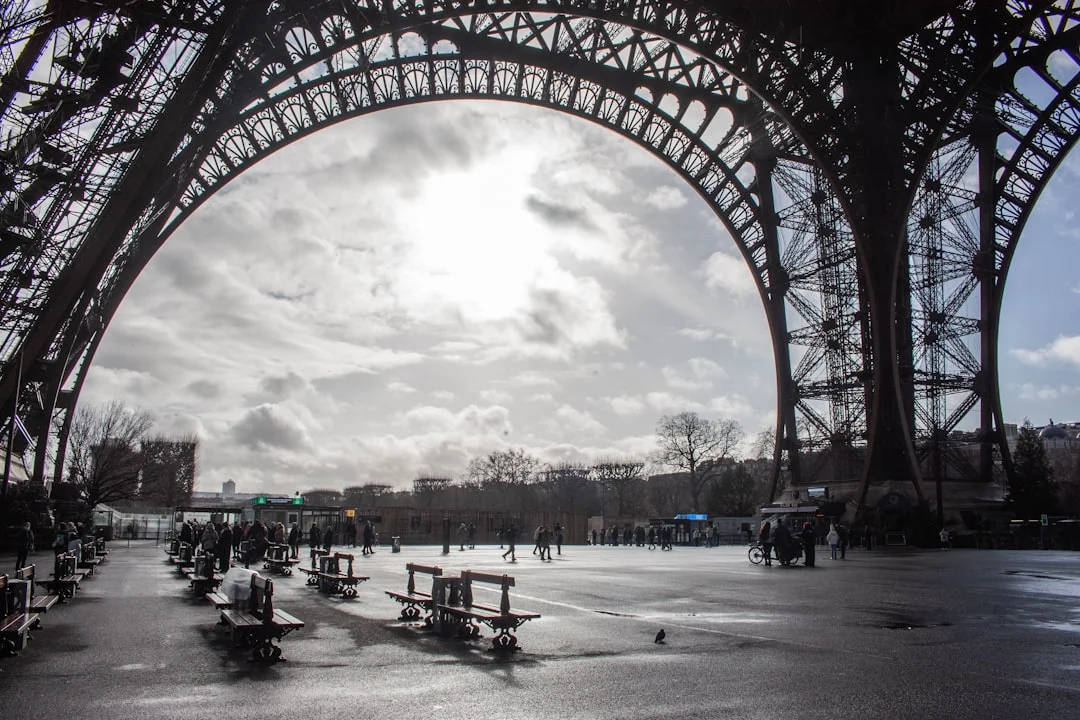 View through eiffel tower arches on a cloudy day.