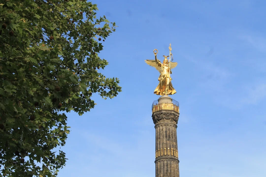 Golden angel atop a monument against blue sky